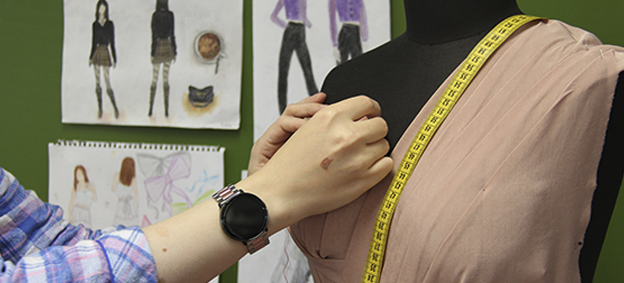 Valokuva vaatetusalan ammattilaisesta työssä.